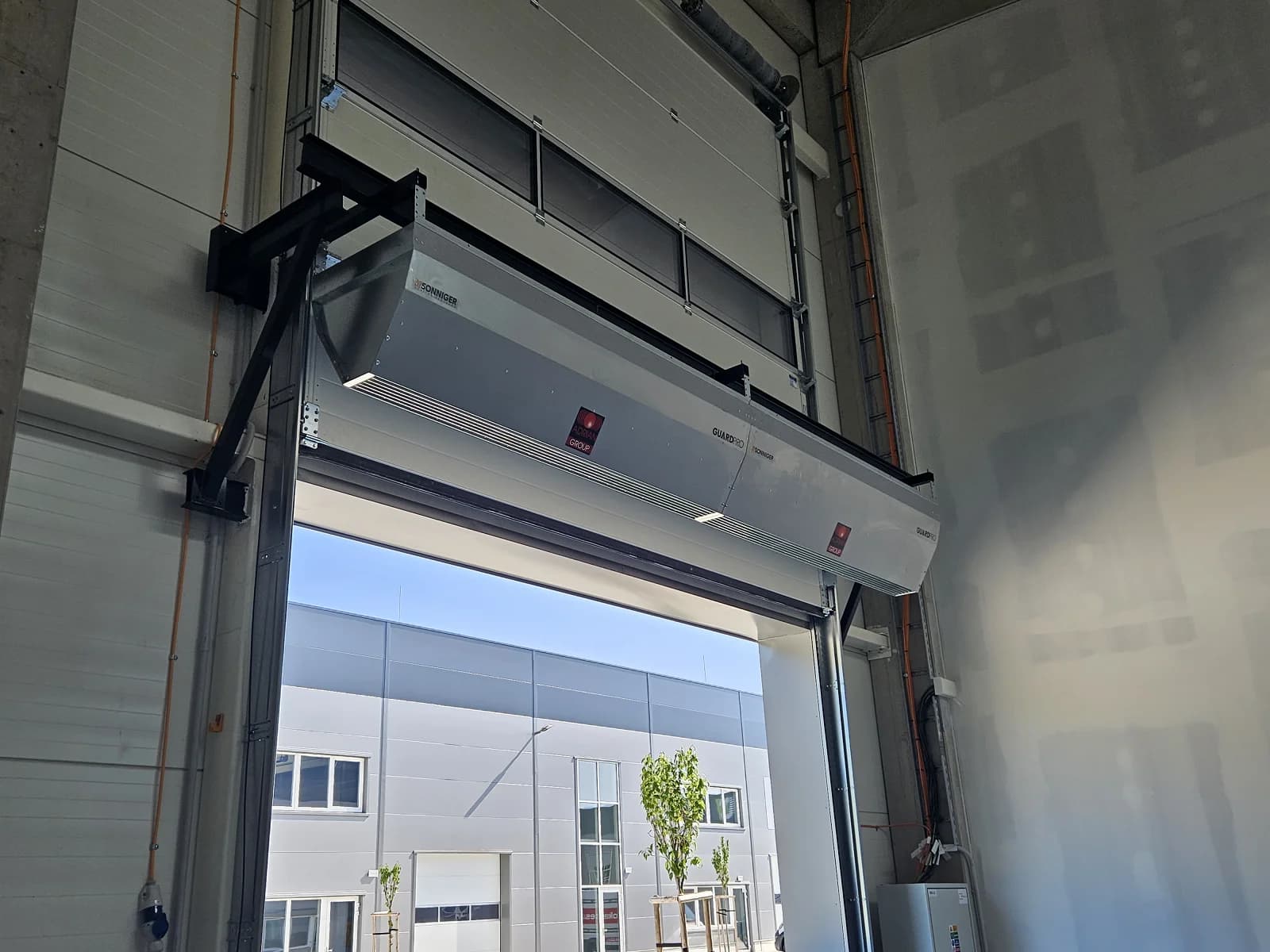 Rideau d'air industriel installé au-dessus d'une porte commerciale dans une installation canadienne